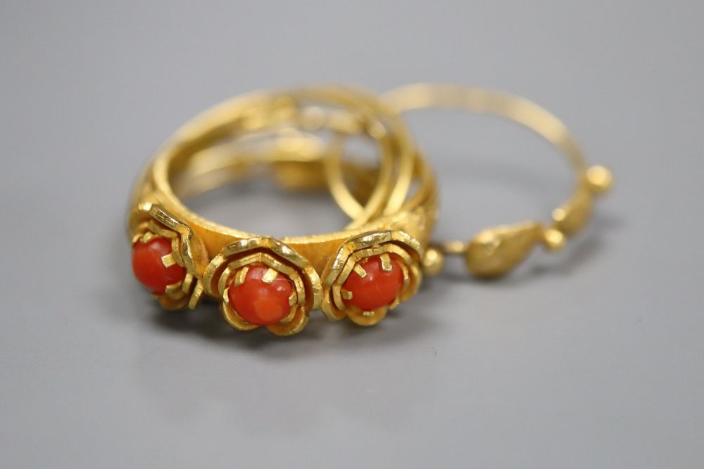 A continental 18k and three stone split coral set multi shank ring, gross 5.7 grams.